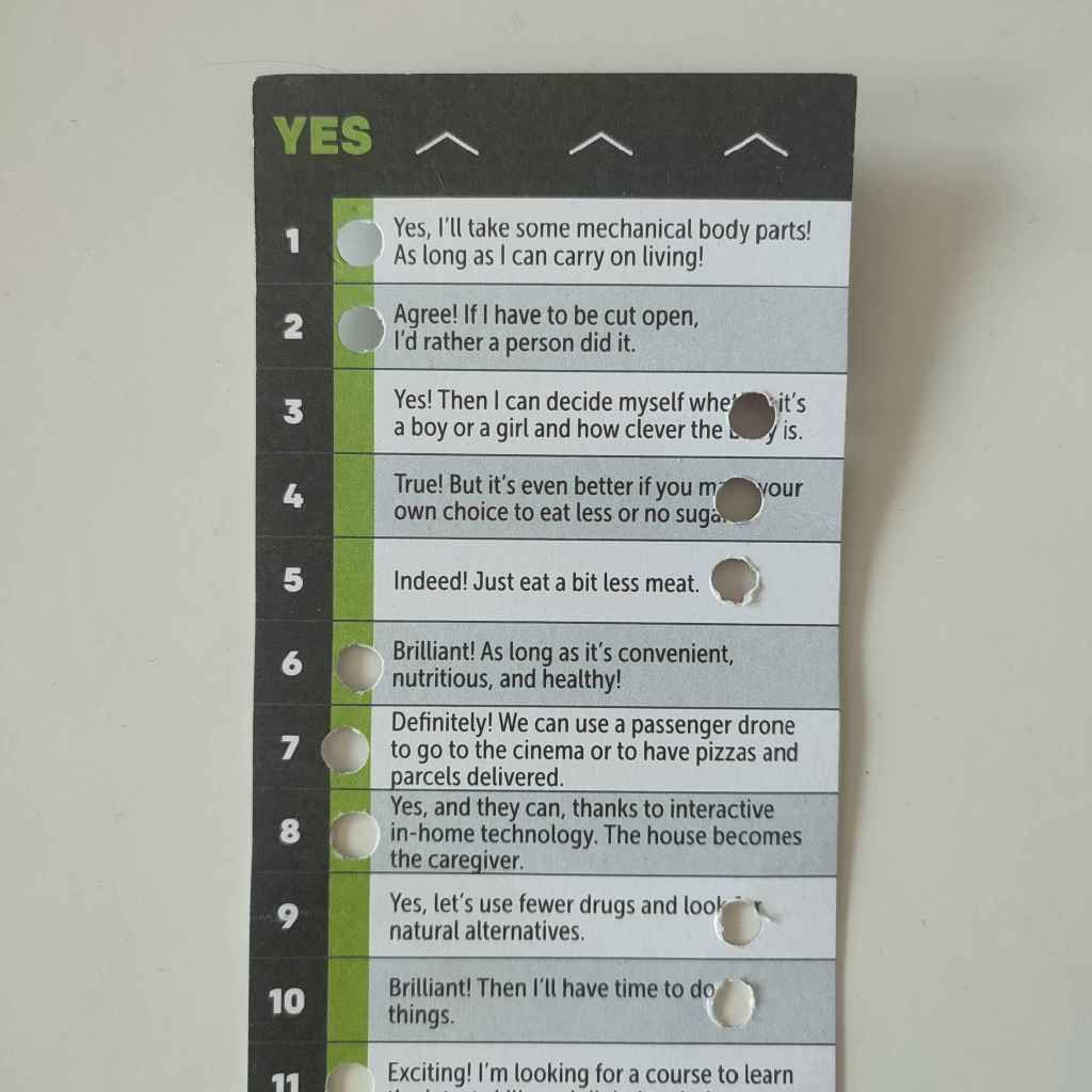 Punch card. Various opinions are written on this side, and holes are punched out of them indicating either personal agreement or disagreement.